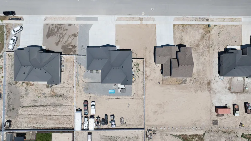 New construction homes featuring dark grey shingle roofs and concrete driveways