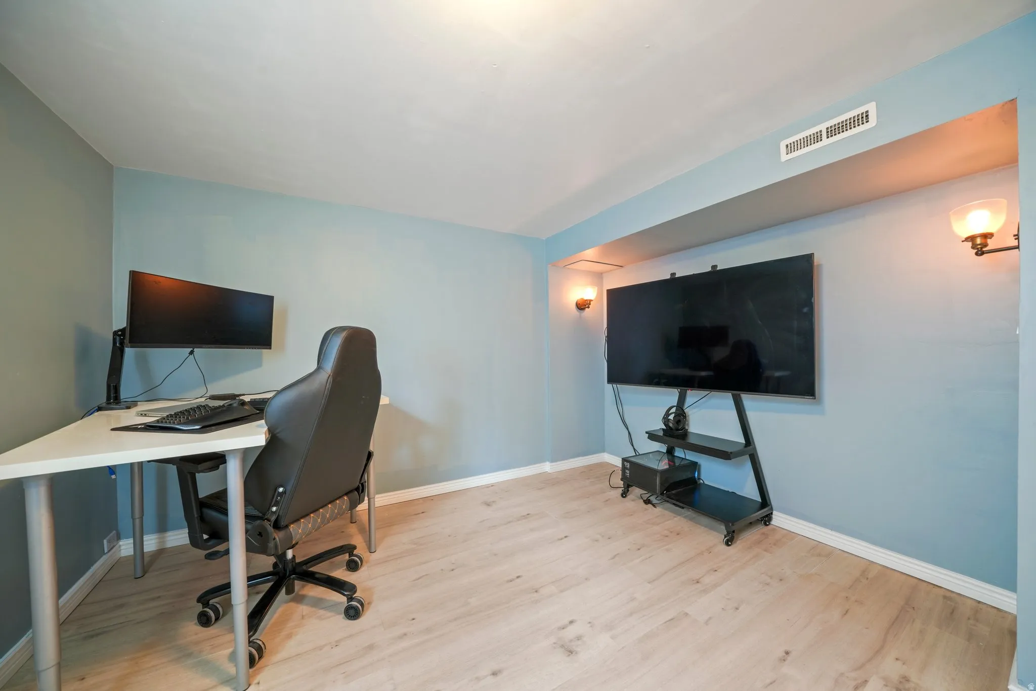 Versatile room with light wood-finish flooring and a neutral wall color