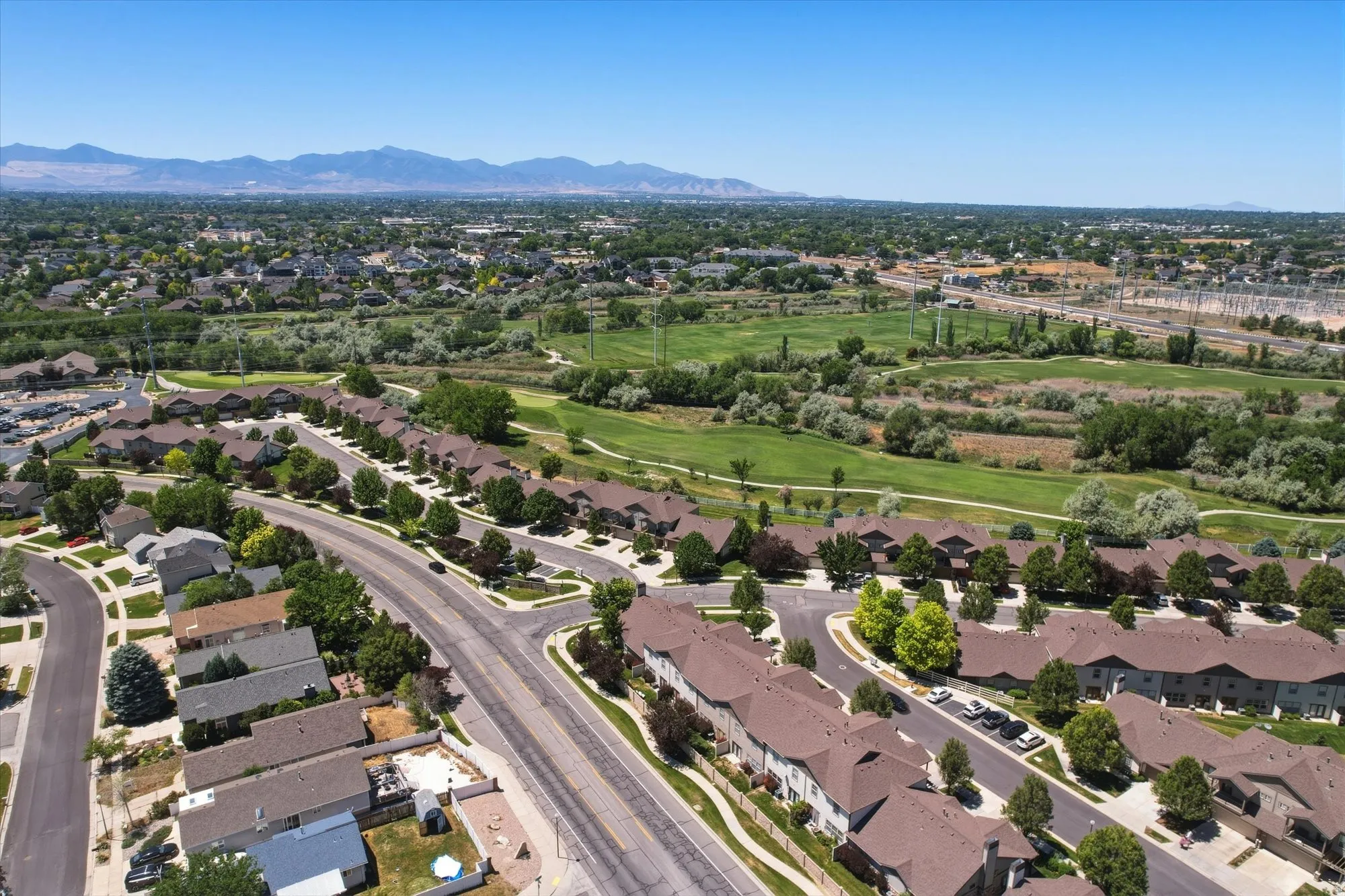 Aerial perspective showcasing a residential community with varied rooflines, paved streets, and mature trees