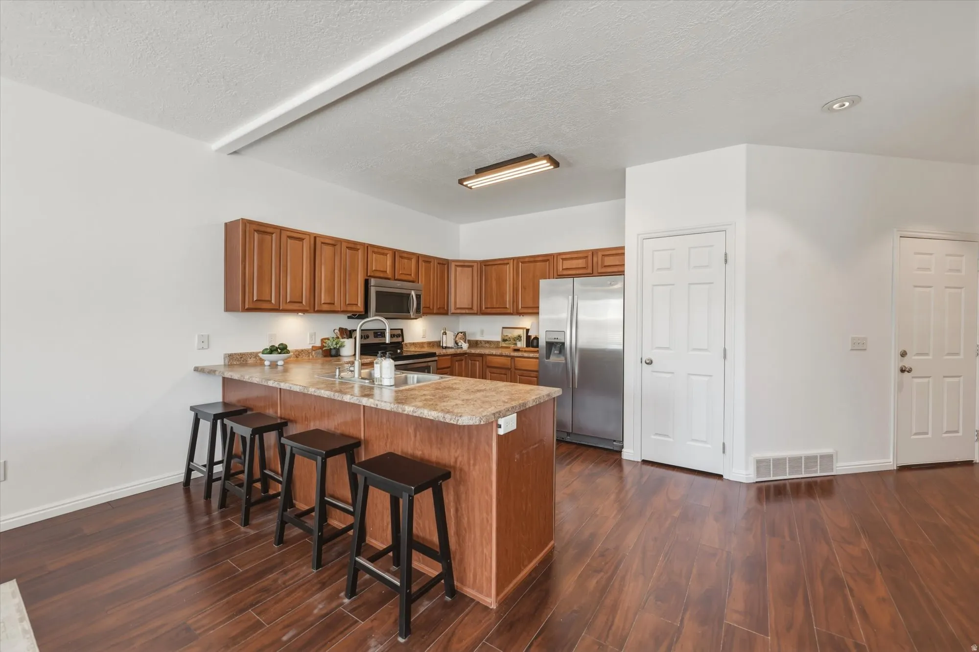 Kitchen featuring wood-finish flooring and a U-shaped layout with an island