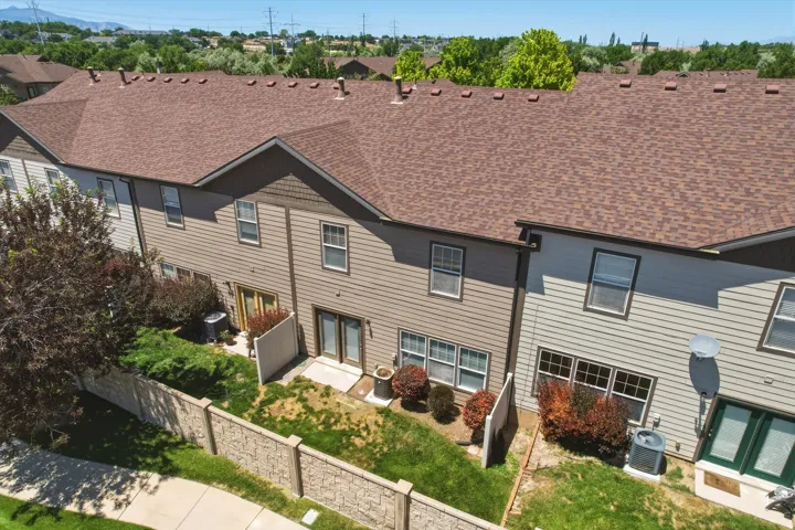 Townhome exteriors featuring horizontal siding, gabled rooflines with asphalt shingles, and ground-level patios with double-door access