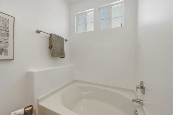 Built-in corner bathtub with deck surround and chrome fixtures