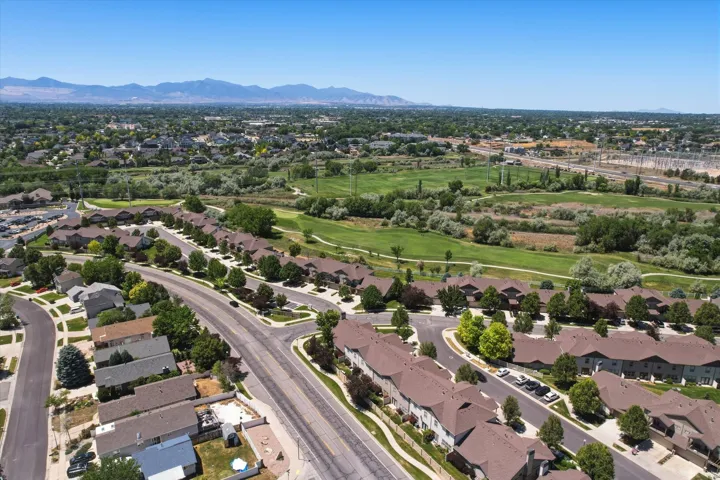 Aerial perspective showcasing a residential community with varied rooflines, paved streets, and mature trees