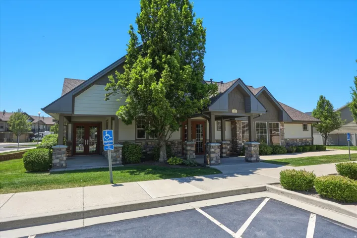 Exterior building featuring a gabled roofline, stone veneer accents, and multiple entryways with double glass doors