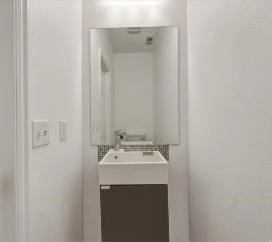 Wall-mounted floating vanity with an integrated rectangular sink and chrome faucet