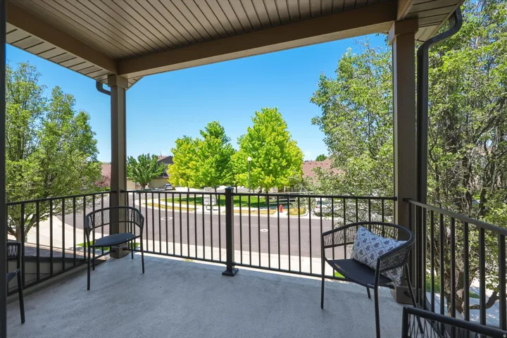 Covered private balcony with a durable concrete floor and black metal railings