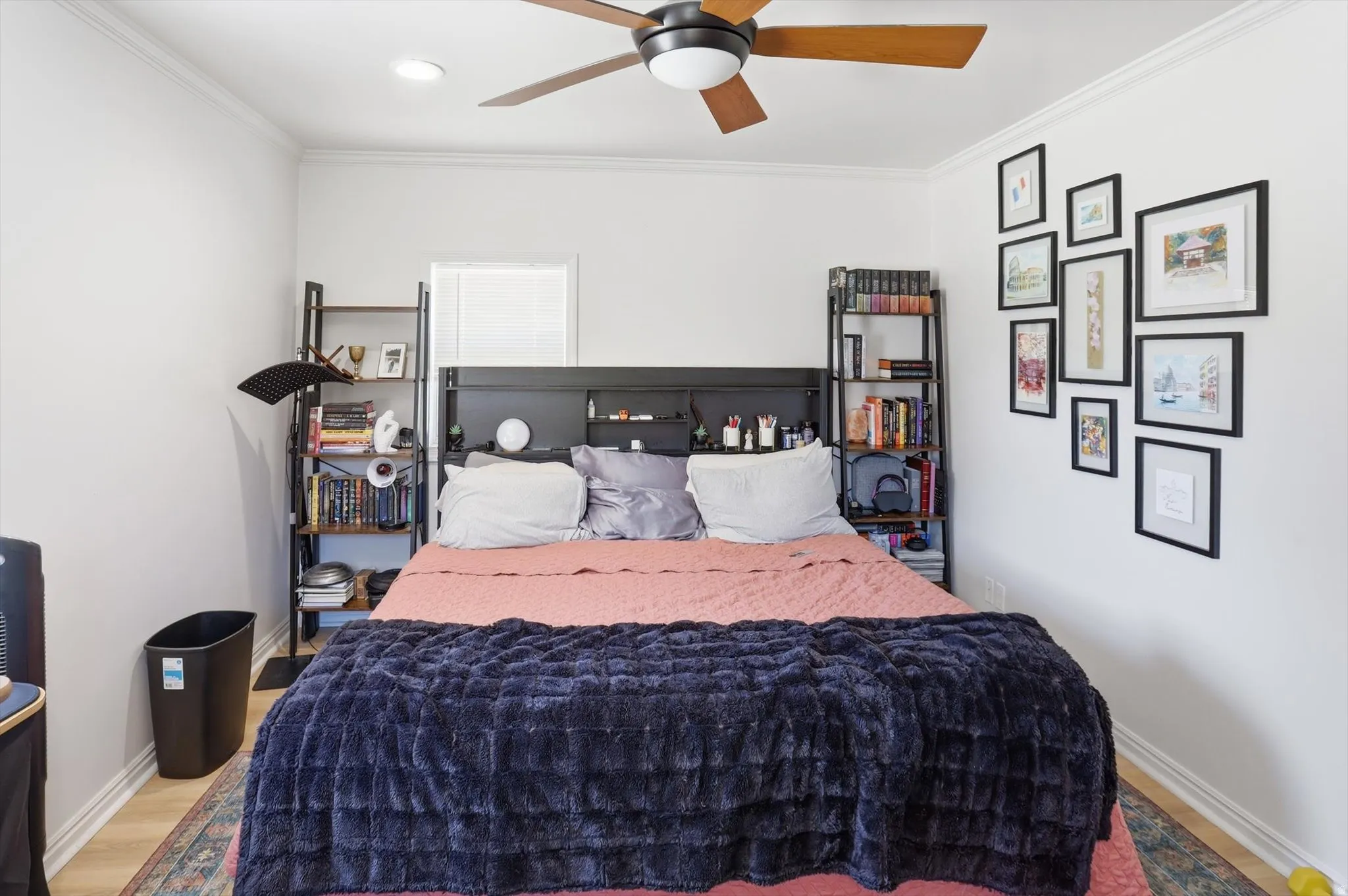 Bedroom featuring wood-finish flooring, a ceiling fan with integrated lighting, recessed lighting, crown molding, and a built-in headboard with integrated shelving