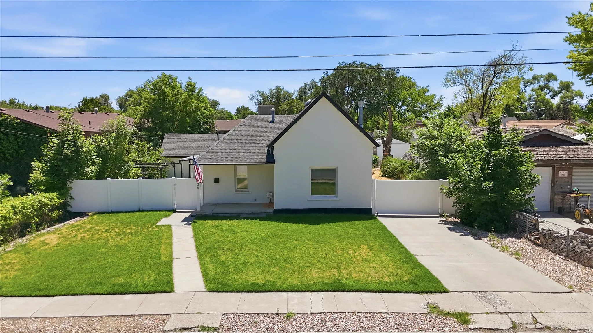 White exterior home with a dark shingle roof and a front porch