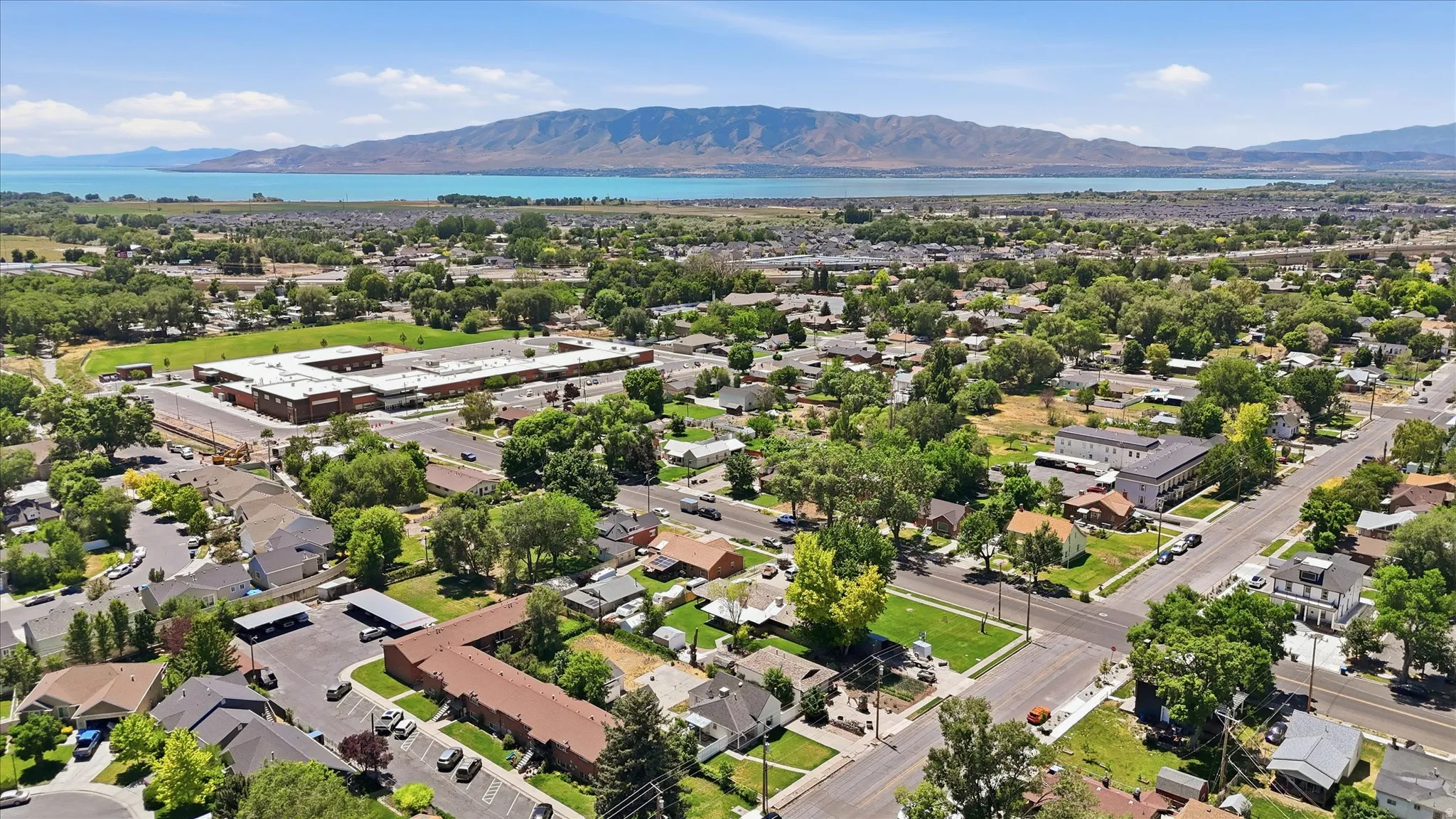 Expansive aerial captures a residential landscape with a prominent body of water and distant mountains