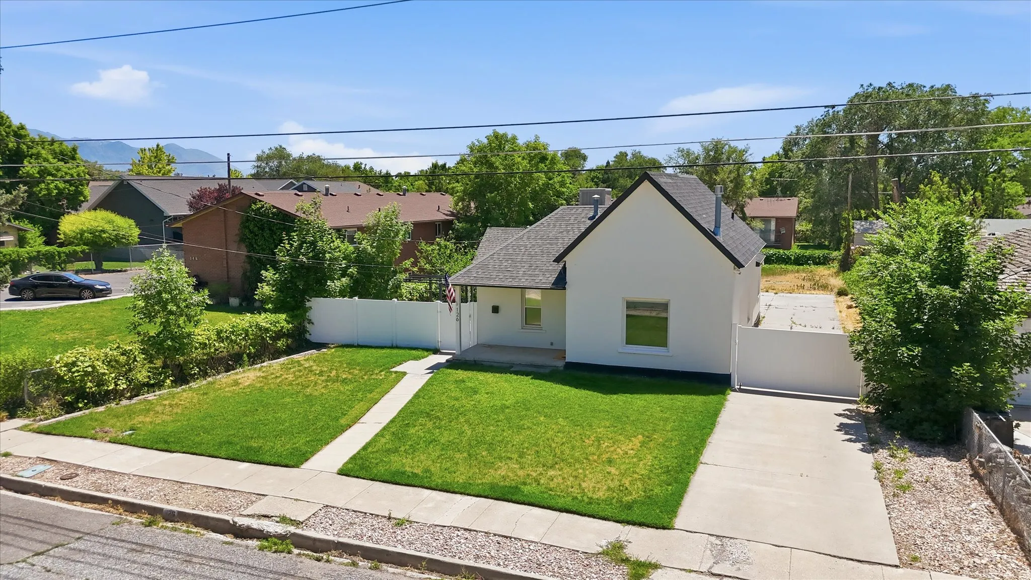 Gable-roof property featuring a white exterior and dark shingle roof
