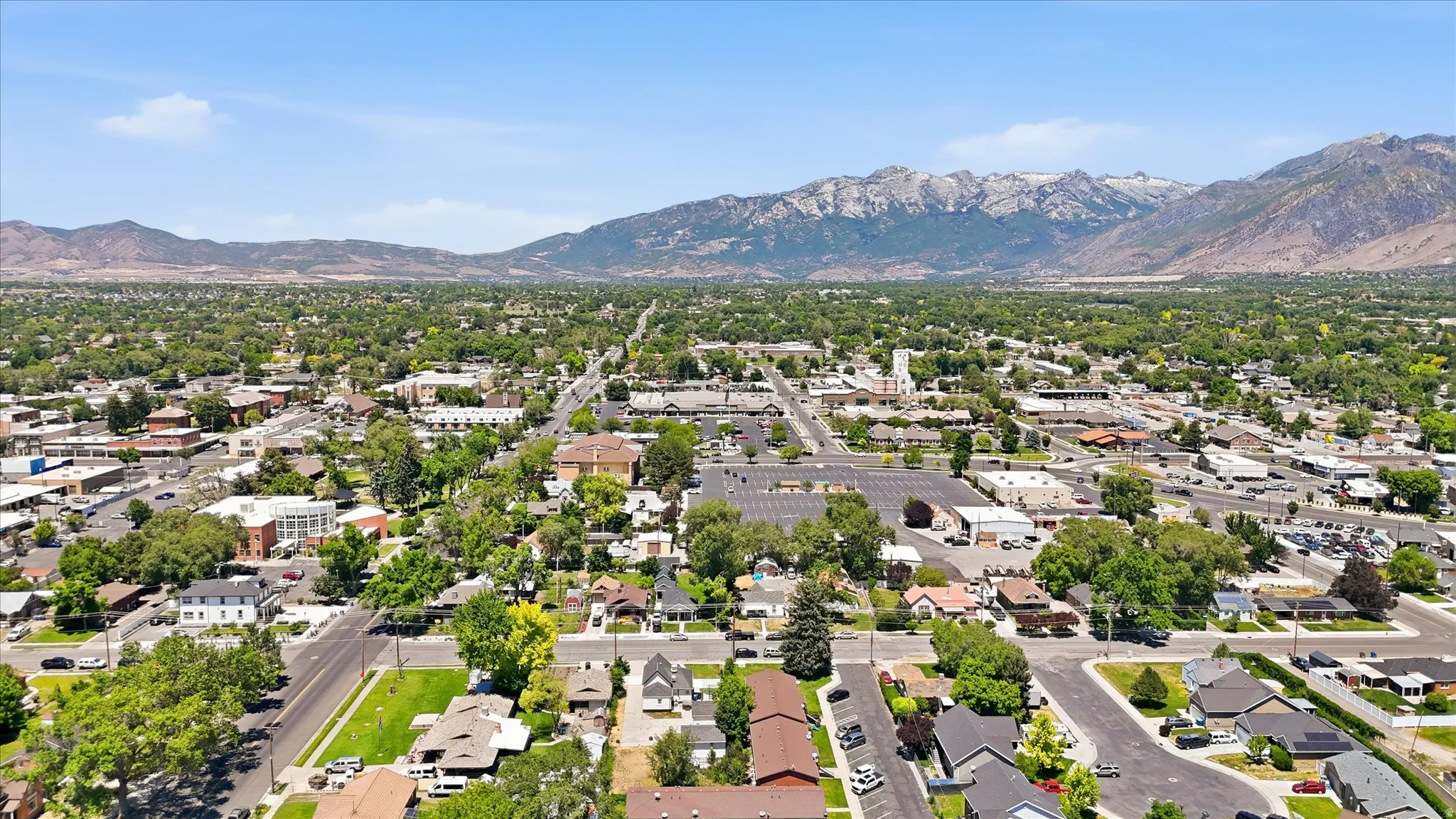 Expansive aerial perspective showcasing a residential and commercial area with mountain backdrop