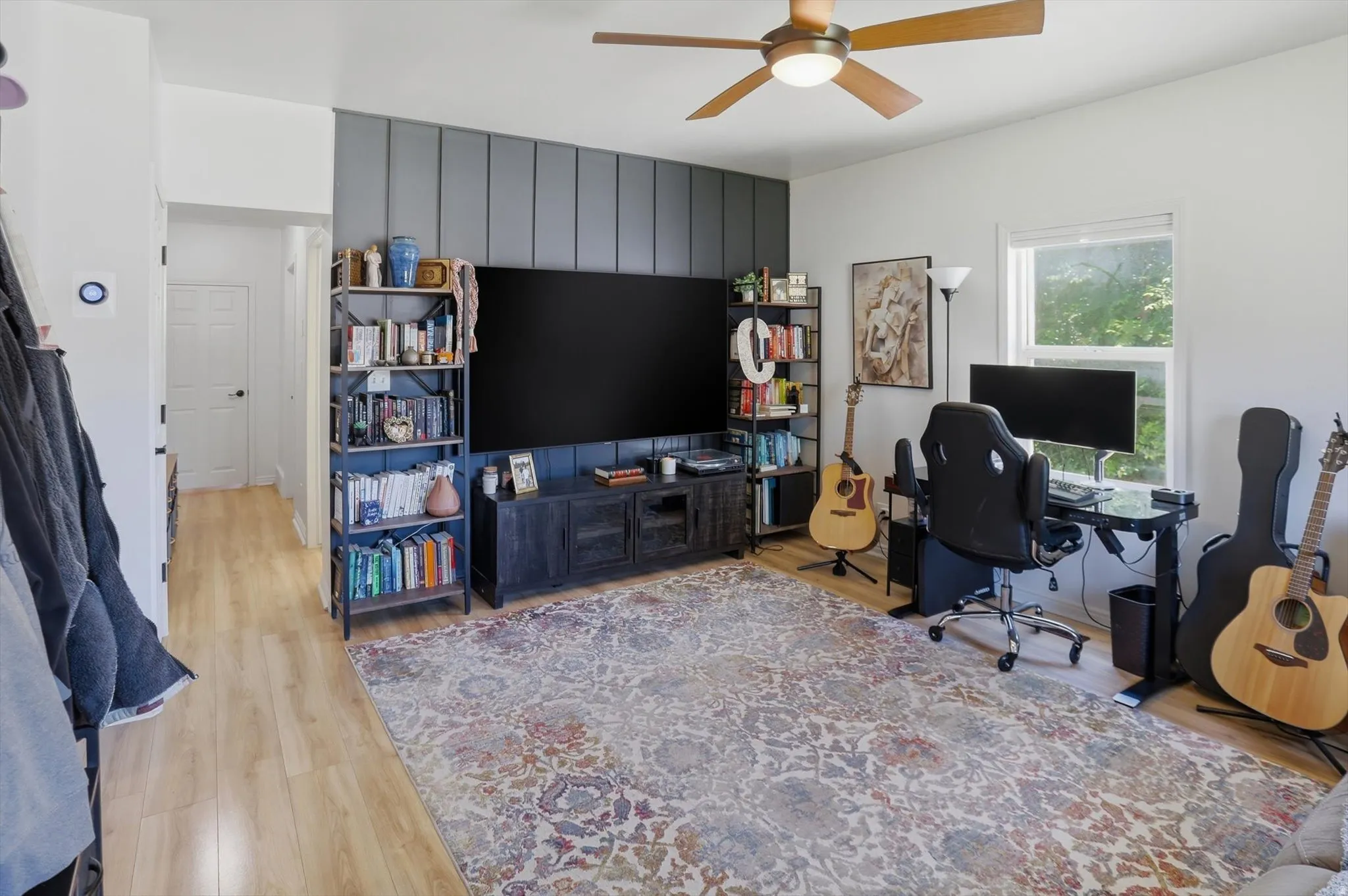 Spacious room featuring light wood-finish flooring and a ceiling fan