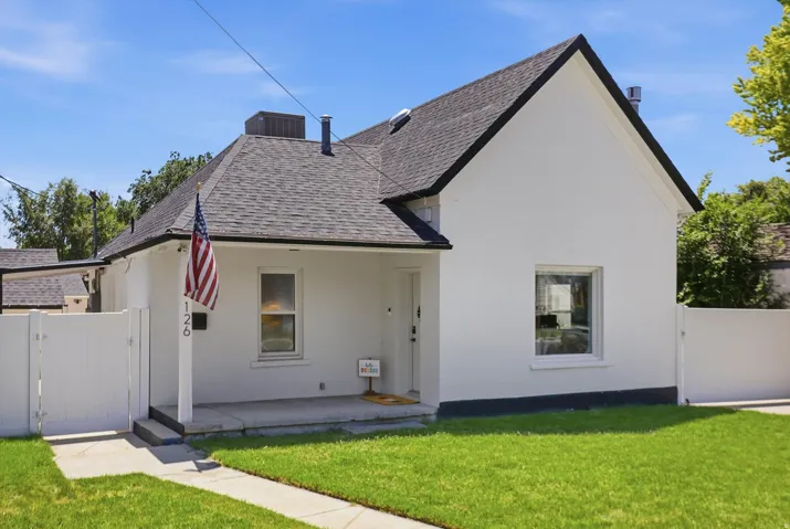 White stucco exterior with dark-trimmed gables and a dark shingled roof