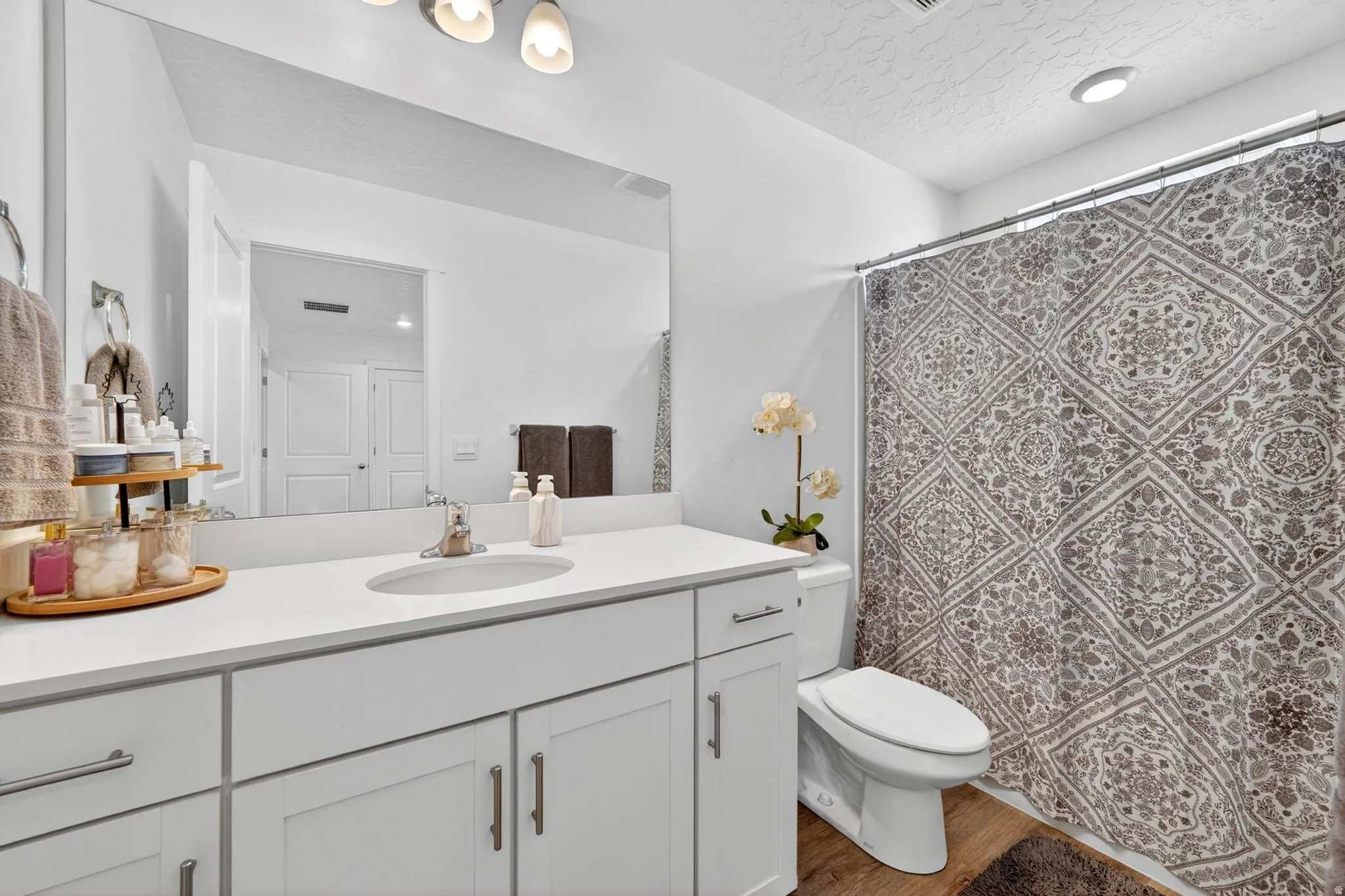 Bathroom featuring a single vanity with white cabinetry, a white countertop, and a basin sink