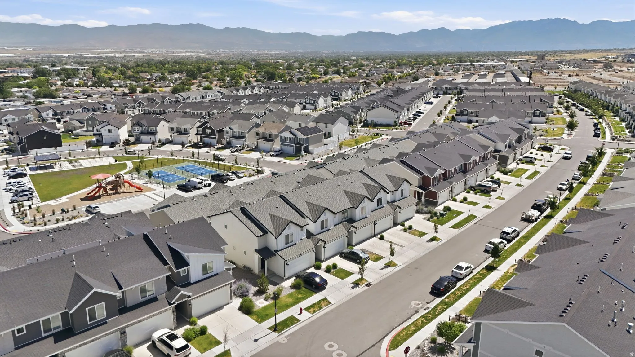 Expansive residential community featuring a variety of housing styles, communal green spaces, and a playground