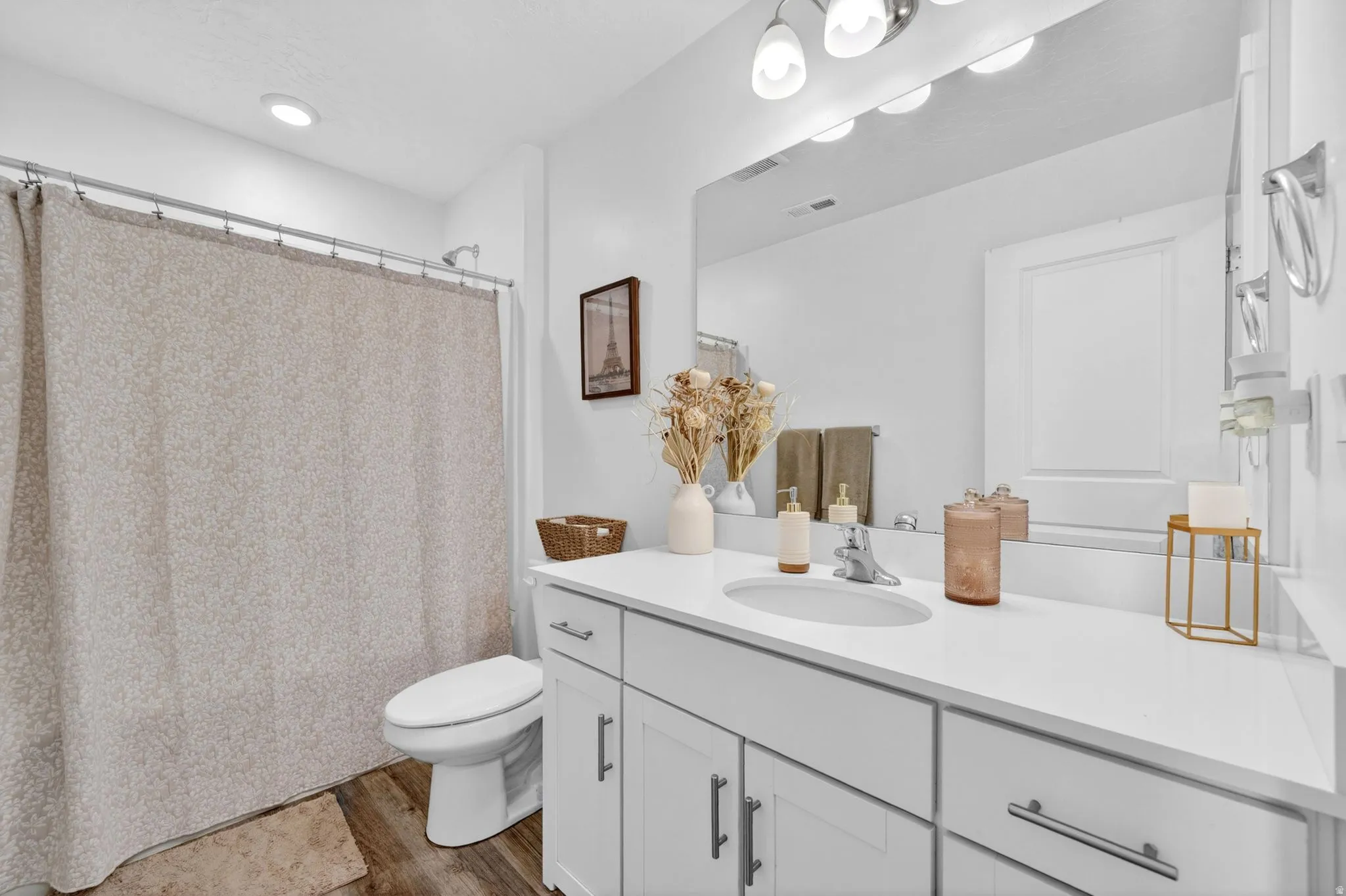 Bathroom featuring a spacious vanity with a white countertop, undermount sink, and chrome faucet