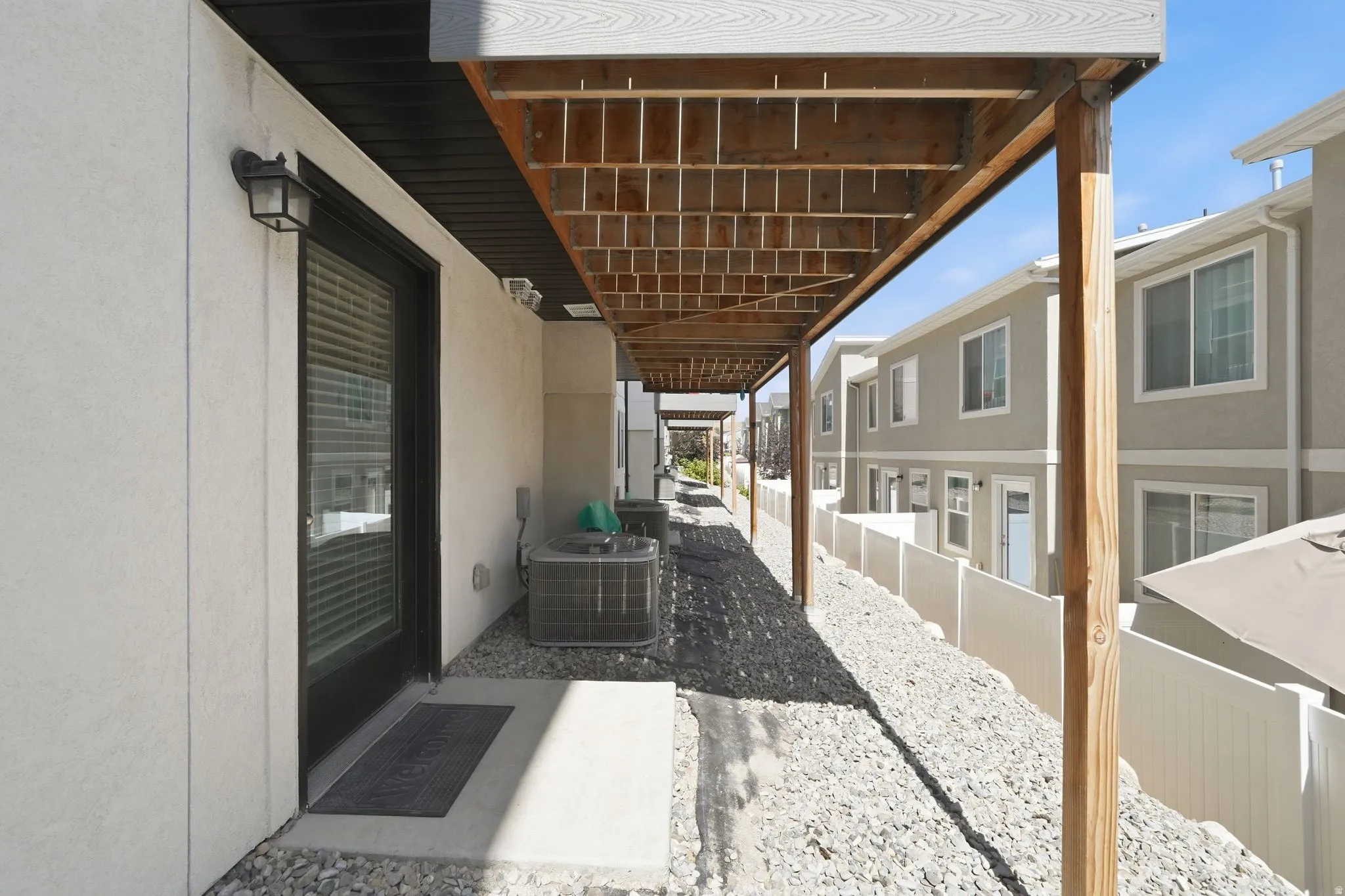 Covered patio space featuring a concrete pad and gravel landscaping