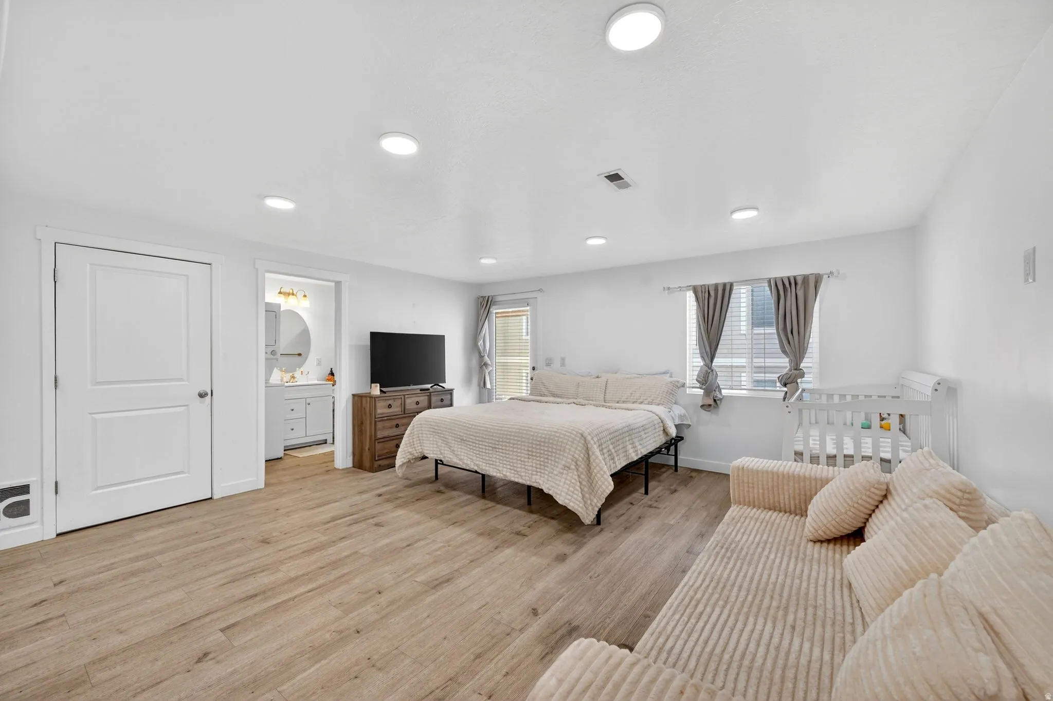 Spacious room featuring wood-finish flooring, recessed lighting, and a window with blinds
