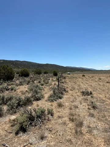 Expansive open land with natural desert vegetation and distant mountain ranges