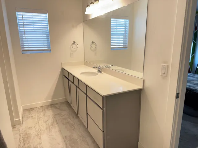 Bathroom featuring a vanity with a white countertop and an integrated sink
