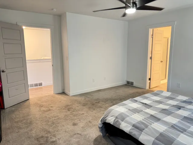 Carpeted room with a contemporary ceiling fan