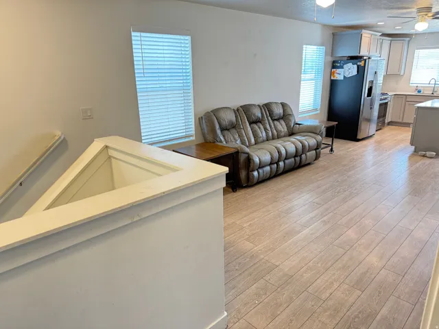 Open-concept living area featuring wood-finish flooring, recessed lighting, and ceiling fans