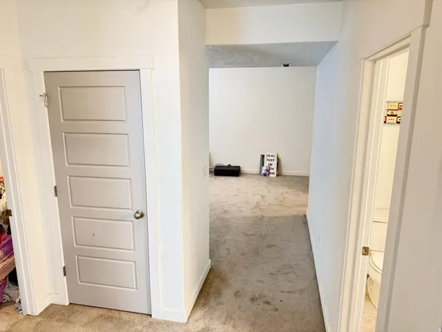 Interior space featuring neutral carpet flooring and white painted walls