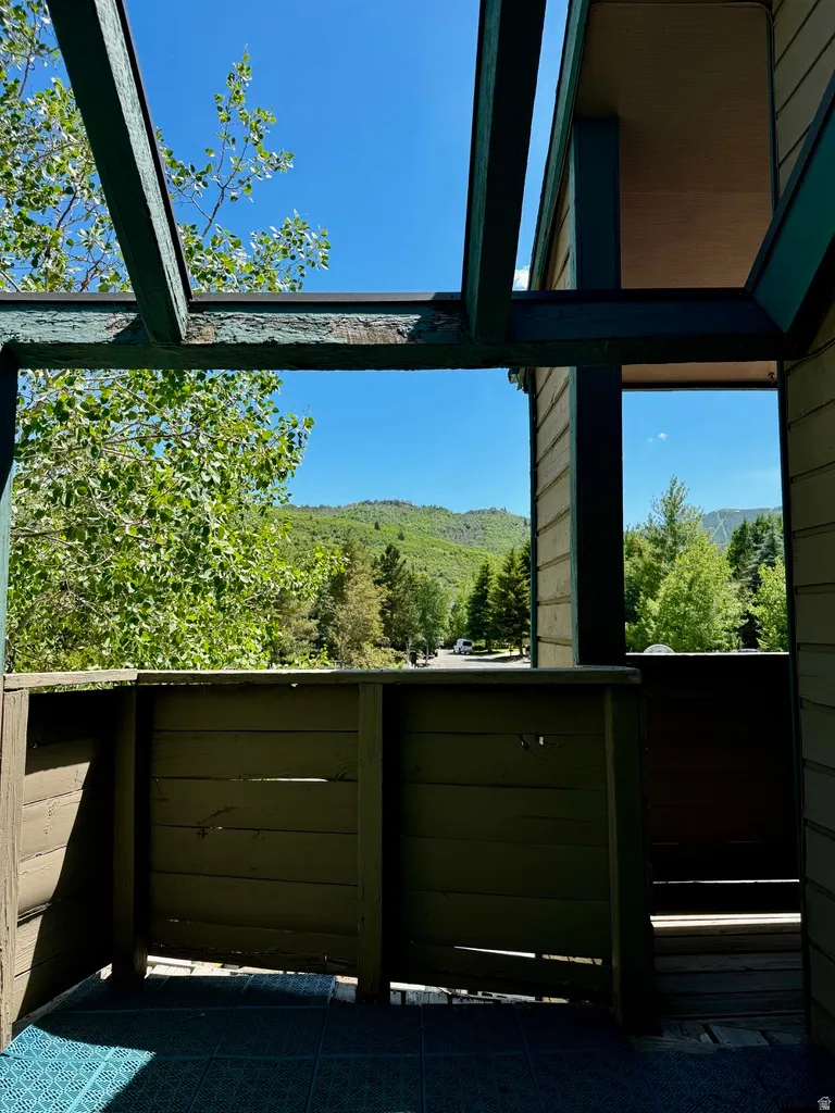 Outdoor balcony with slat-paneled enclosure and open pergola