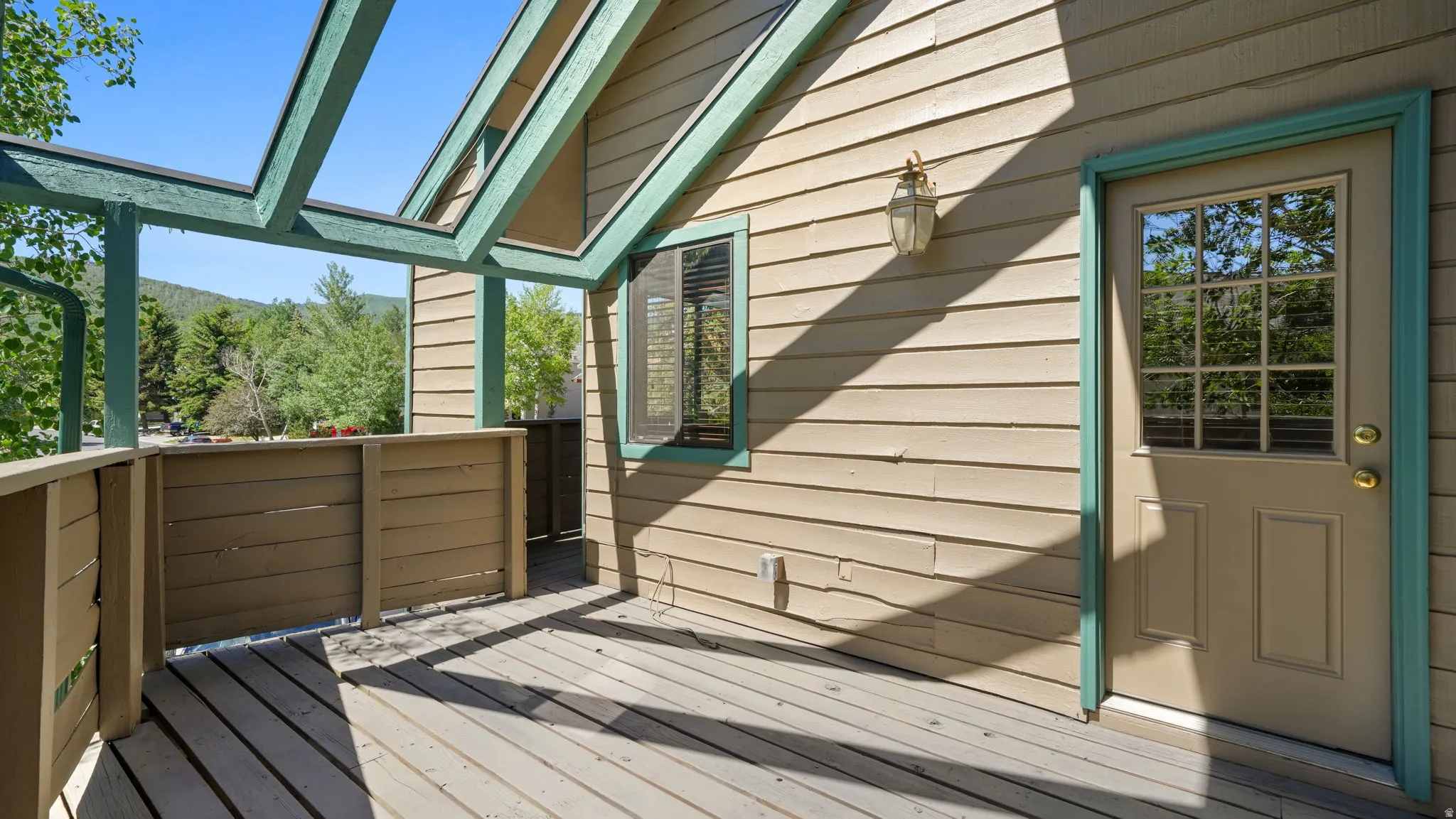 Exterior deck featuring wood flooring, a decorative pergola, and a privacy wall