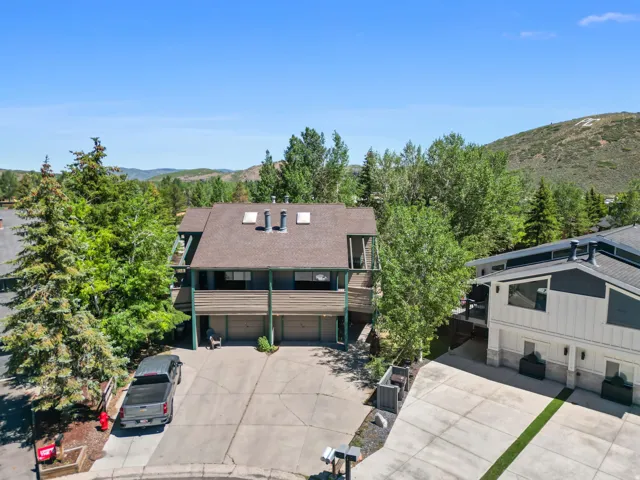 Multi-level exterior with a brown shingle roof, dual upper balconies, and a multi-car driveway
