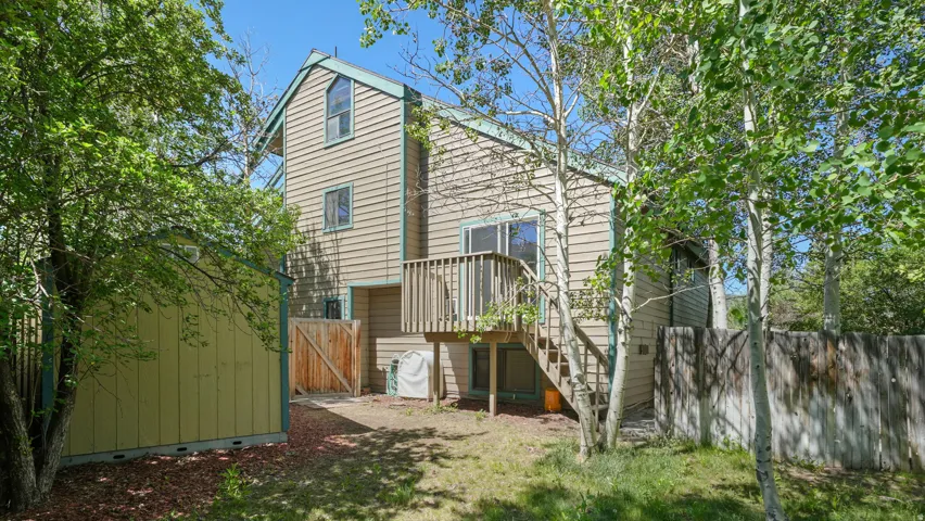Two-story exterior with horizontal siding and accent trim, featuring a raised wooden deck with stairs