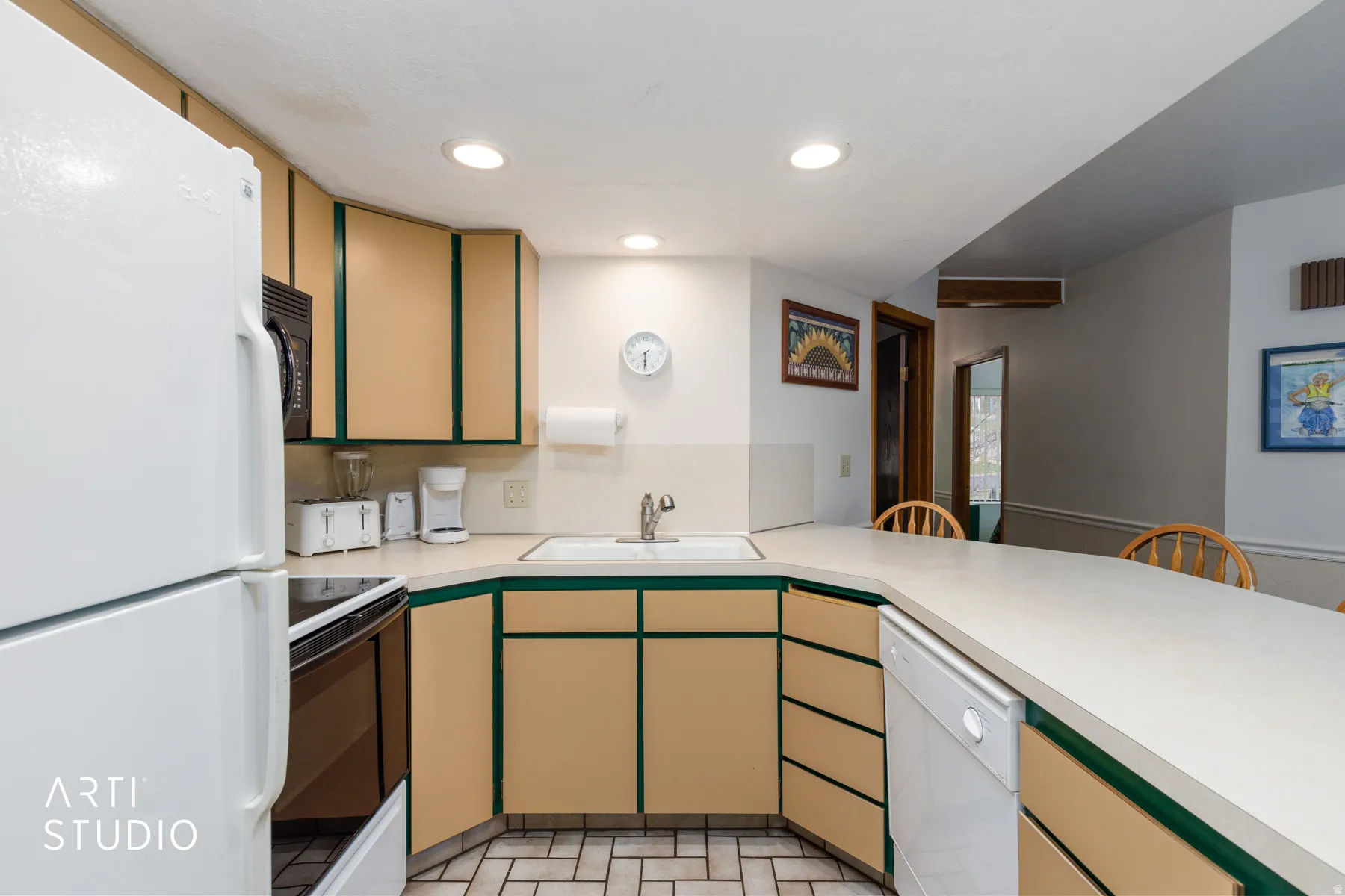 Kitchen featuring a built-in dishwasher, an integrated sink, recessed lighting, tile flooring, and a breakfast bar