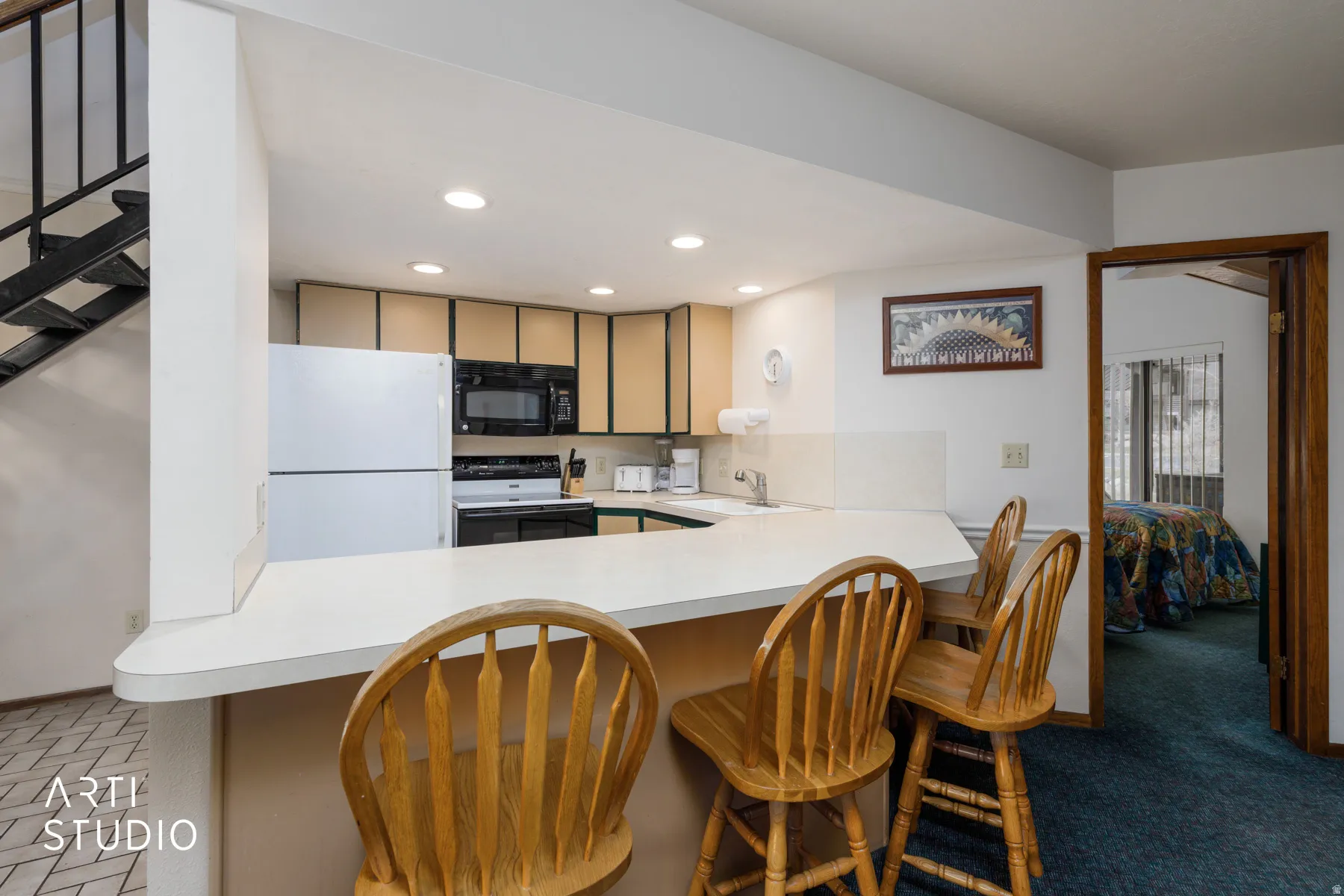 Kitchen featuring a breakfast bar with seating, white appliances, and warm-toned cabinetry