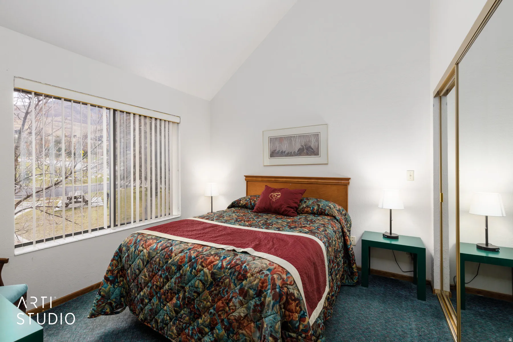 Vaulted ceilings highlight this room with a large window and mirrored closet doors