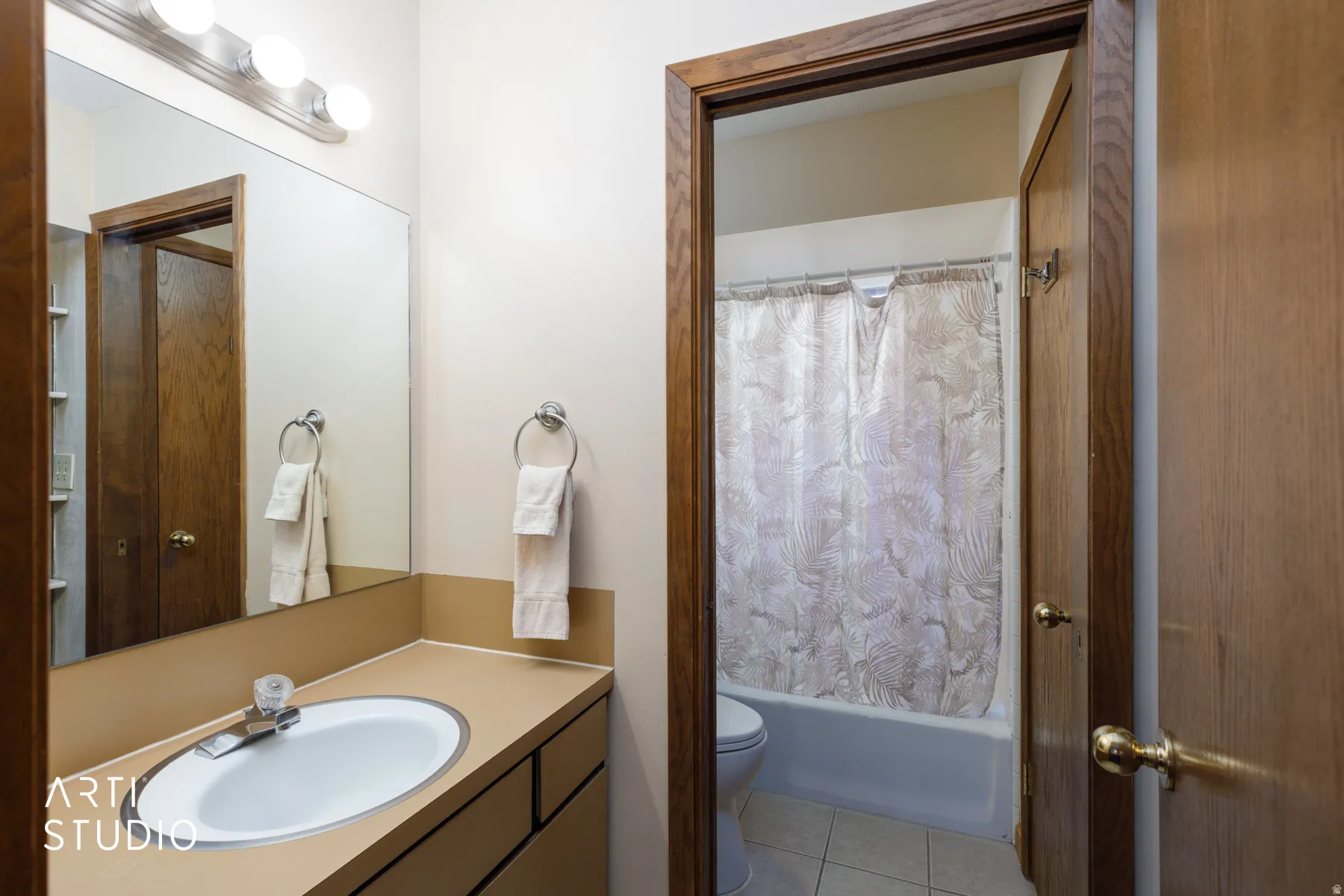 Bathroom vanity featuring a single basin sink and a mirror with overhead lighting
