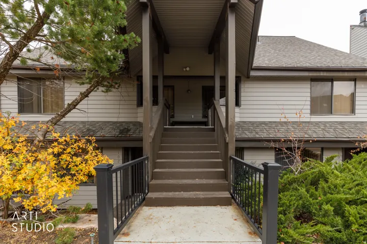 Multi-level exterior entrance featuring dark wood steps and railings