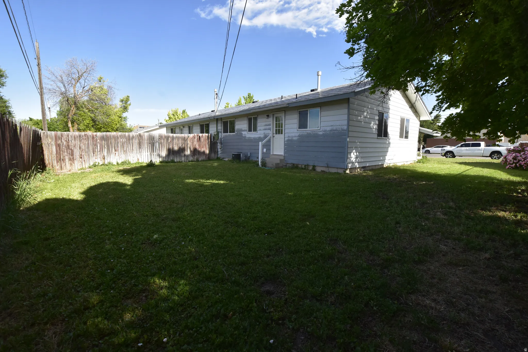 Expansive lawn area enclosed by a wood plank fence