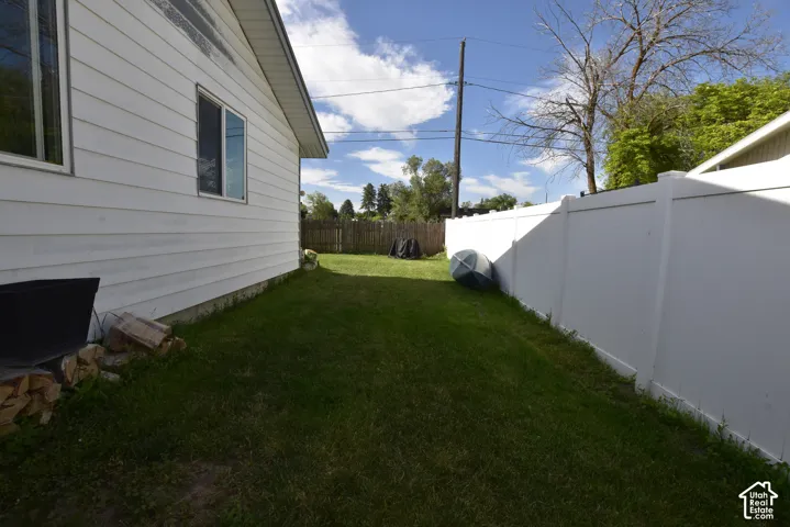 Expansive grass yard with a white vinyl fence and white siding
