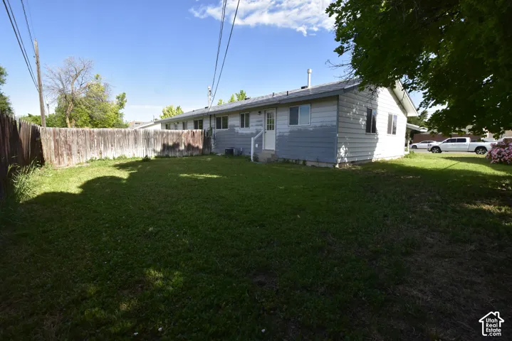 Expansive lawn area enclosed by a wood plank fence