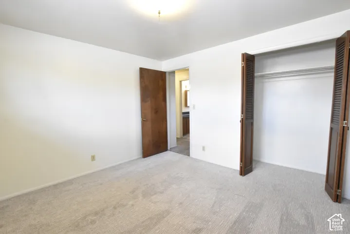 Bedroom featuring light-toned carpeting, white walls, and a ceiling-mounted light fixture