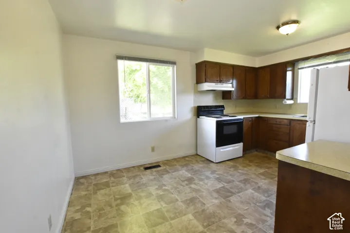 Kitchen featuring wood cabinetry, laminate countertops, and resilient flooring