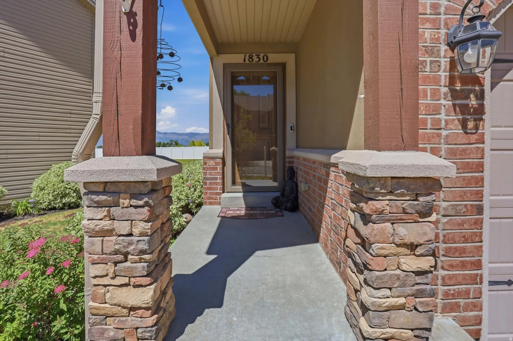 Covered entry featuring wood-finish columns and stacked stone accents