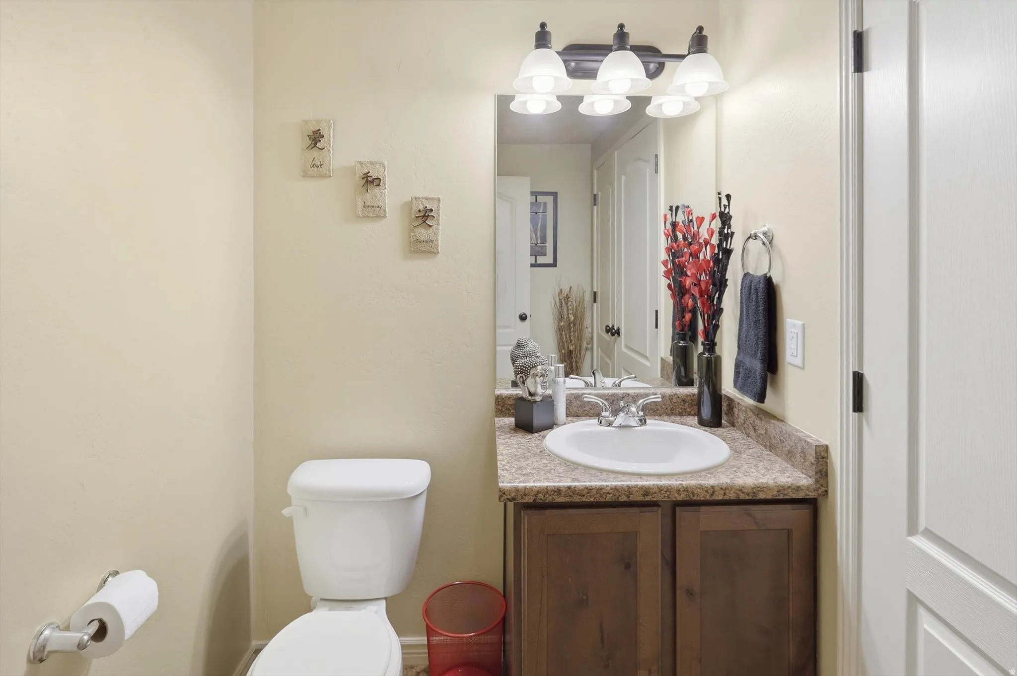 Bathroom vanity featuring a dark wood-finish cabinet with silver hardware, an integrated oval sink, and a speckled countertop