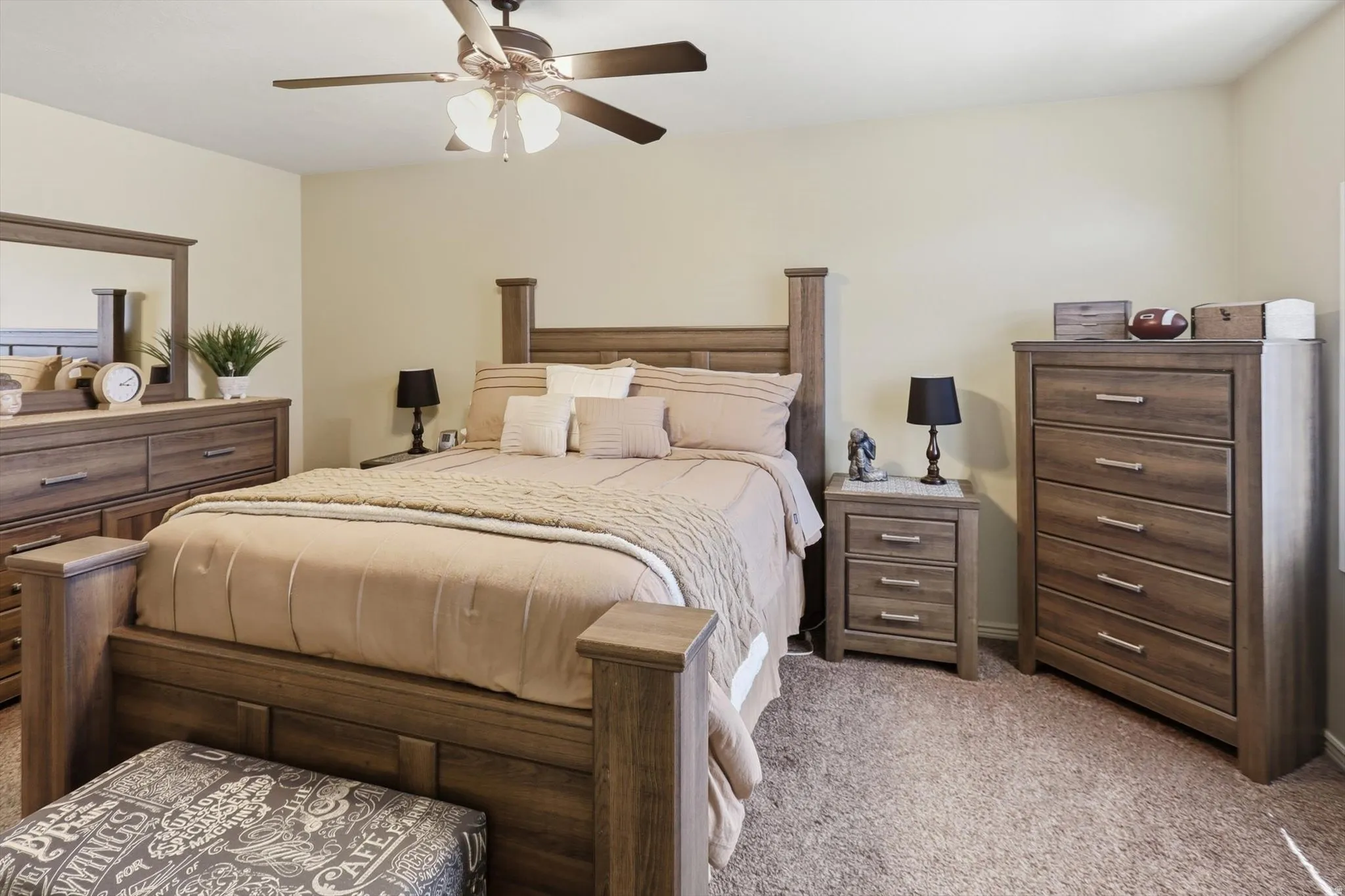 Spacious bedroom featuring neutral-toned walls and plush carpet flooring