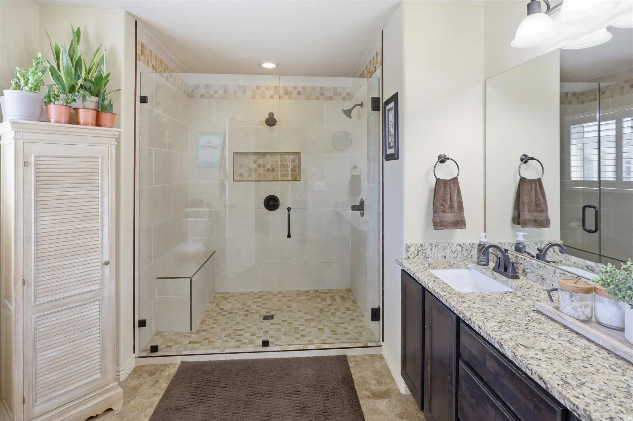 Walk-in shower with clear glass enclosure and integrated bench seating