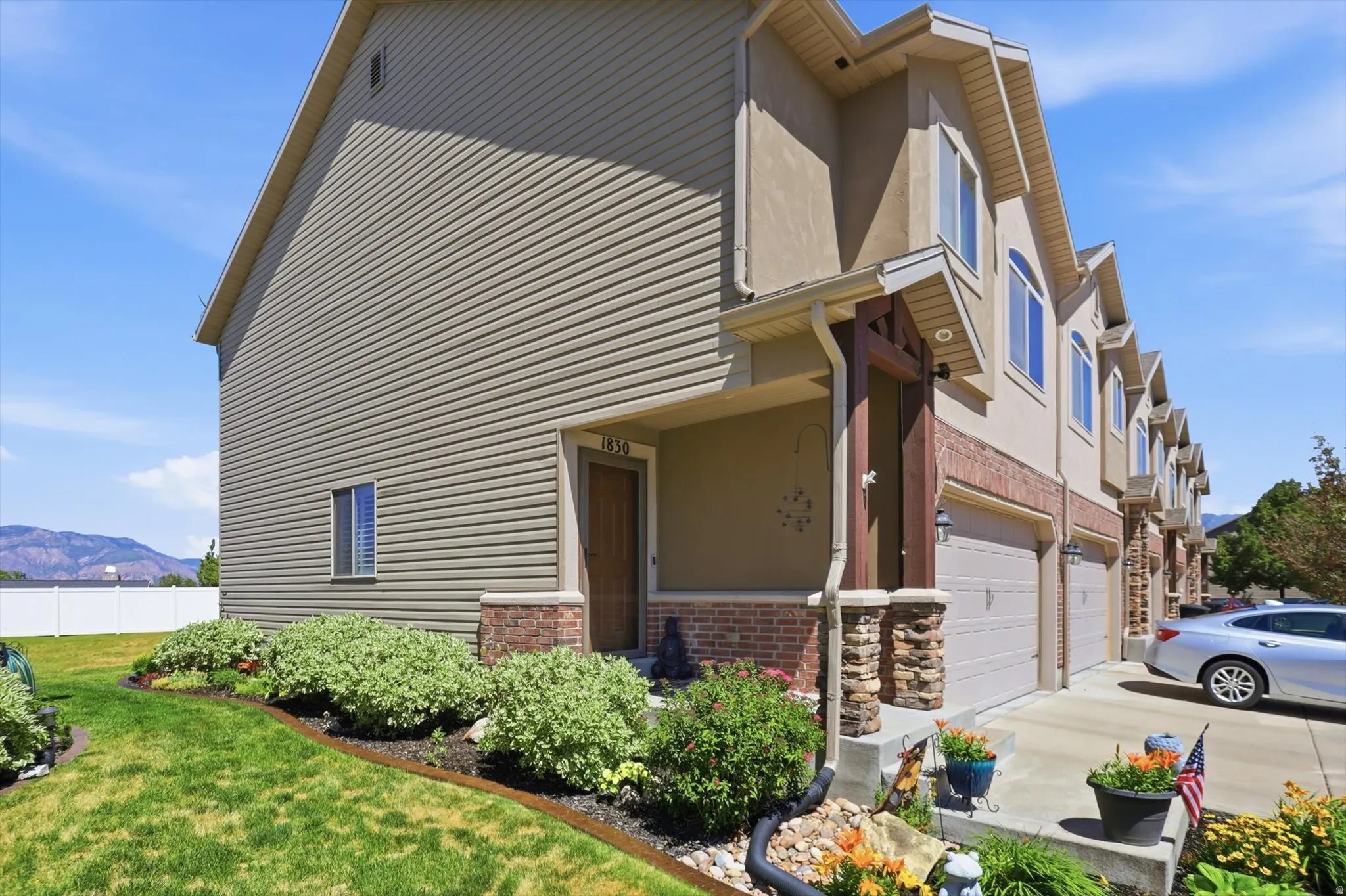 End-unit townhome with multi-textured exterior featuring beige siding, stucco, and brick accents