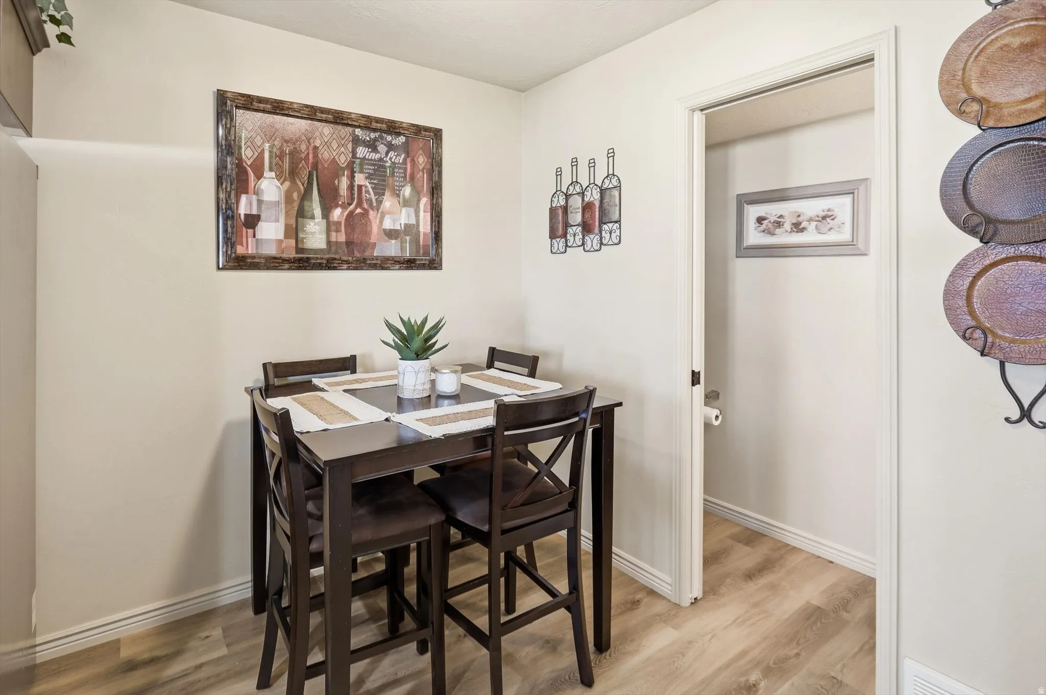Dining area featuring wood-finish flooring, light-toned walls, and a convenient doorway