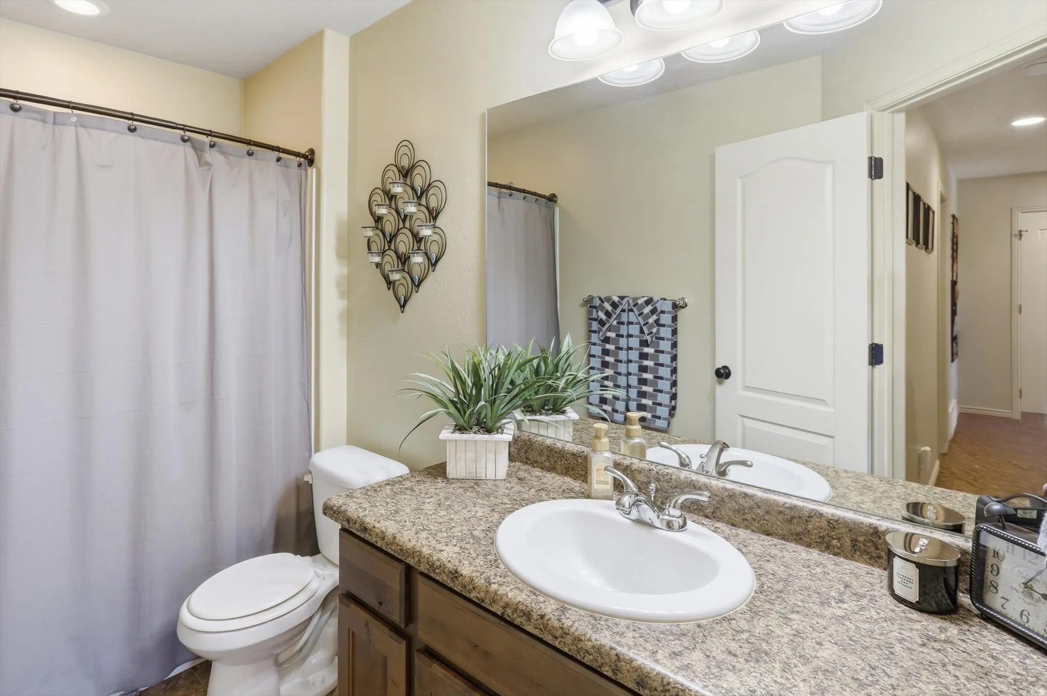 Bathroom featuring a vanity with a laminate countertop, integrated sink, and wood-finish cabinetry