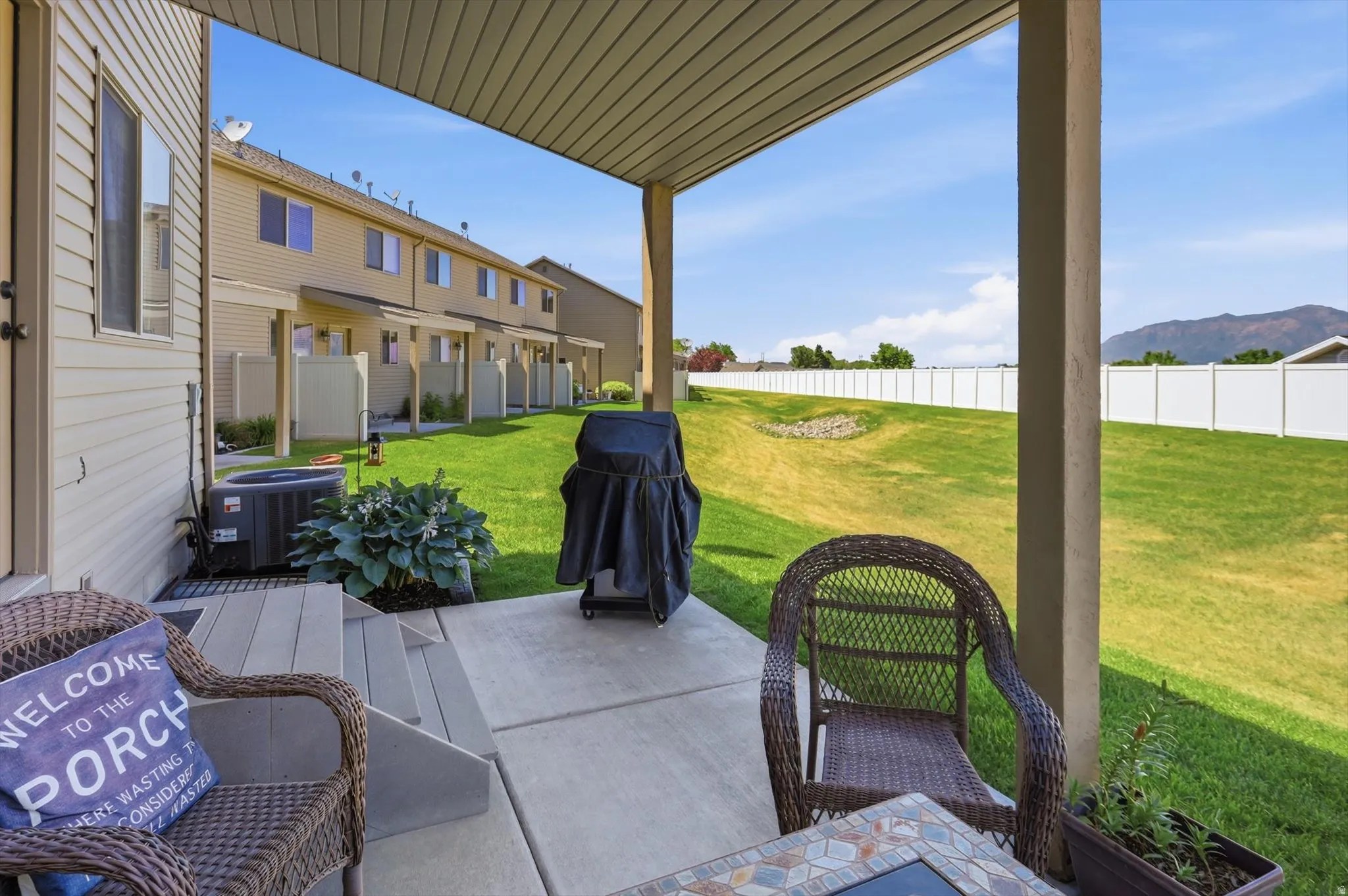 Covered patio featuring concrete flooring and a partial privacy wall