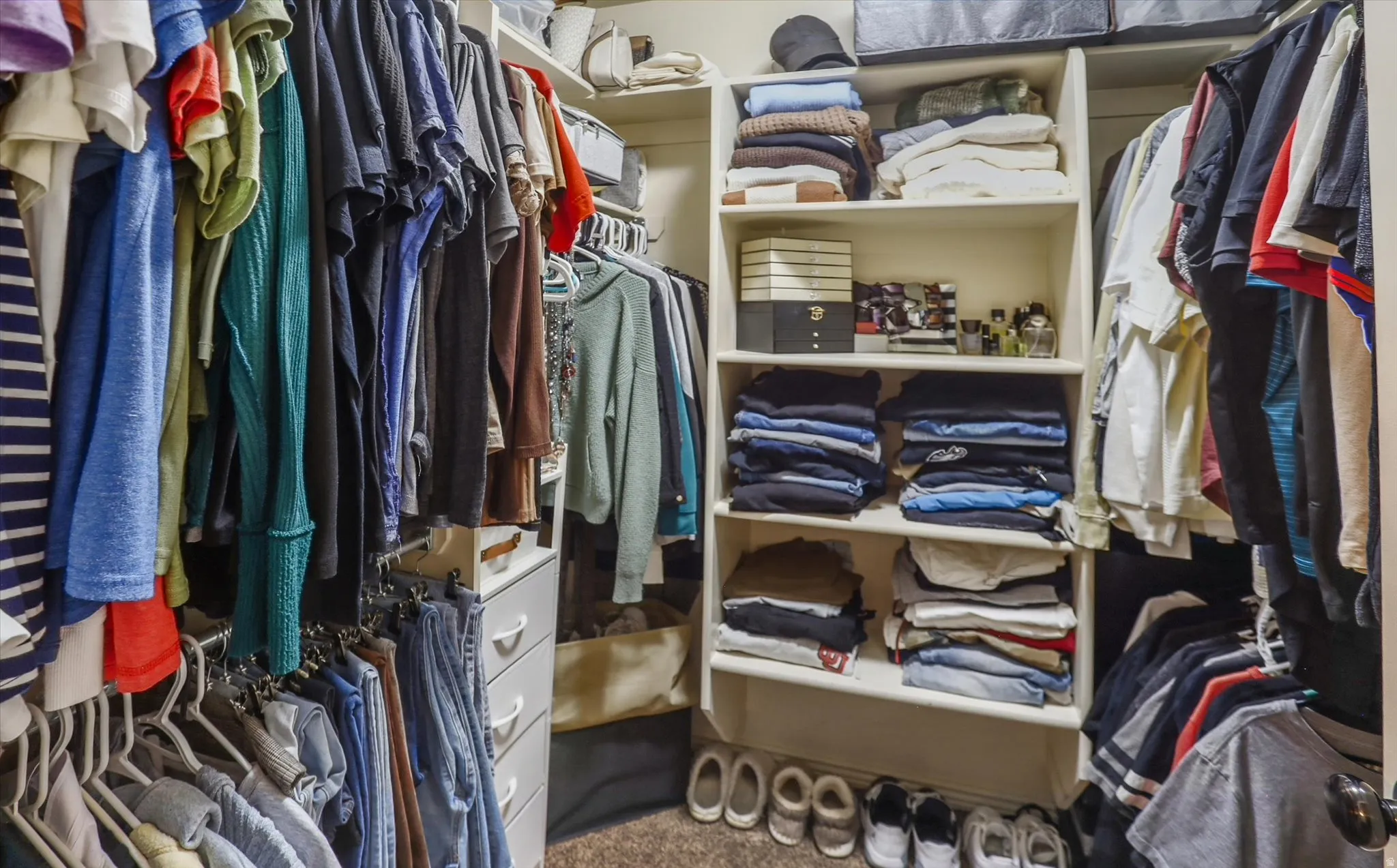 Custom closet organization system featuring multiple hanging rods, integrated shelving, and built-in drawer storage